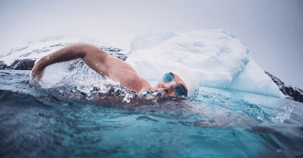 Swimmer Lewis Pugh swims in cold water next to an iceberg